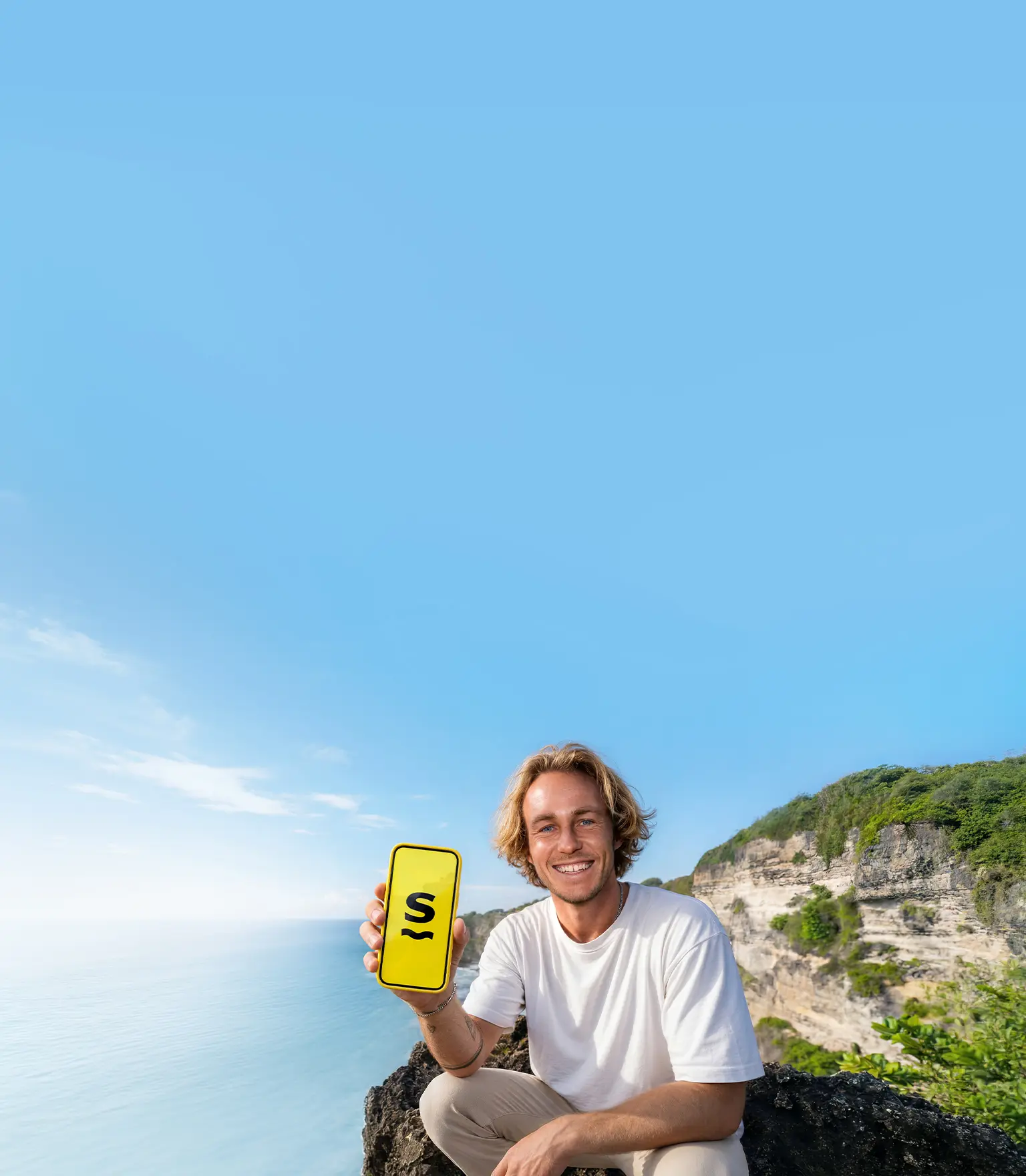 A man holding a phone with the Saily eSIM app logo on its screen.