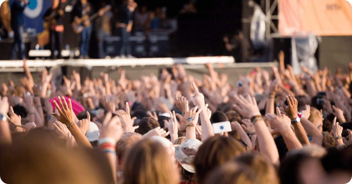 A crowd of Americans listen to music at a festival.
