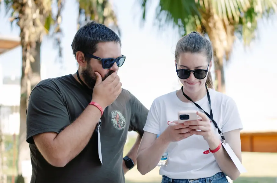 Los empleados de Saily se reunieron alrededor de un teléfono durante un evento empresarial.