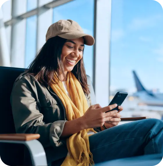 スマートフォンでSailyの遅延フライト補償サービスを利用している女性。