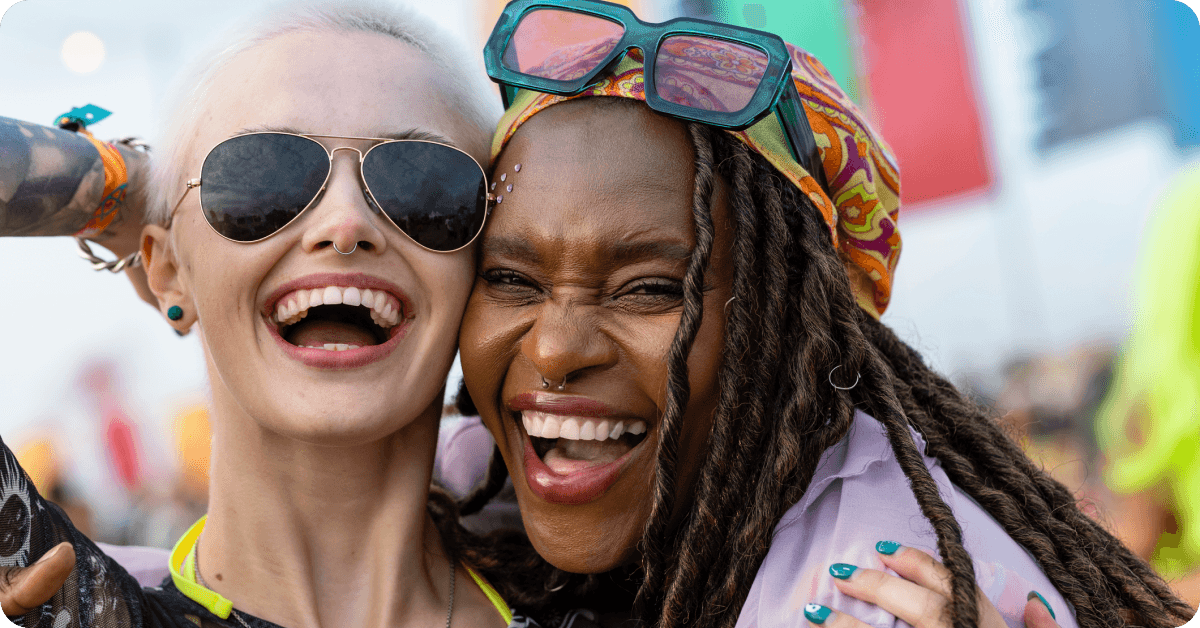 Two women laugh together at a Jamaican music festival.