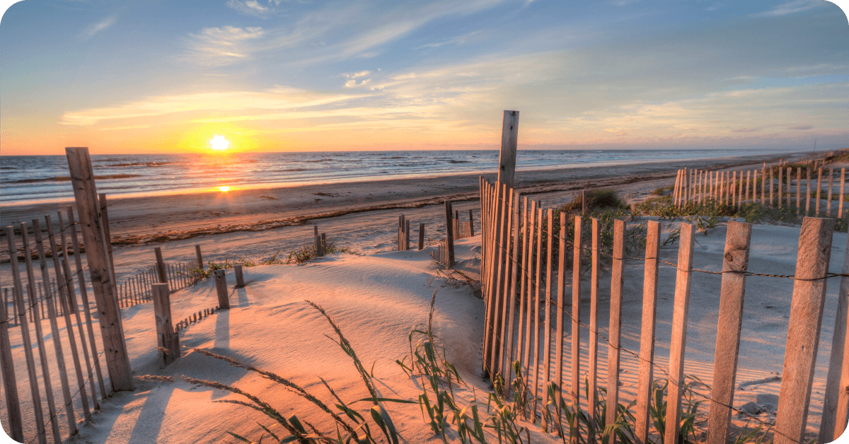 A wooden fence leads to a beach in the Outer Banks