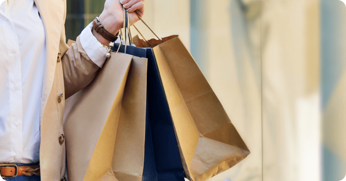 A shopper carries bags from a Parisian department store.
