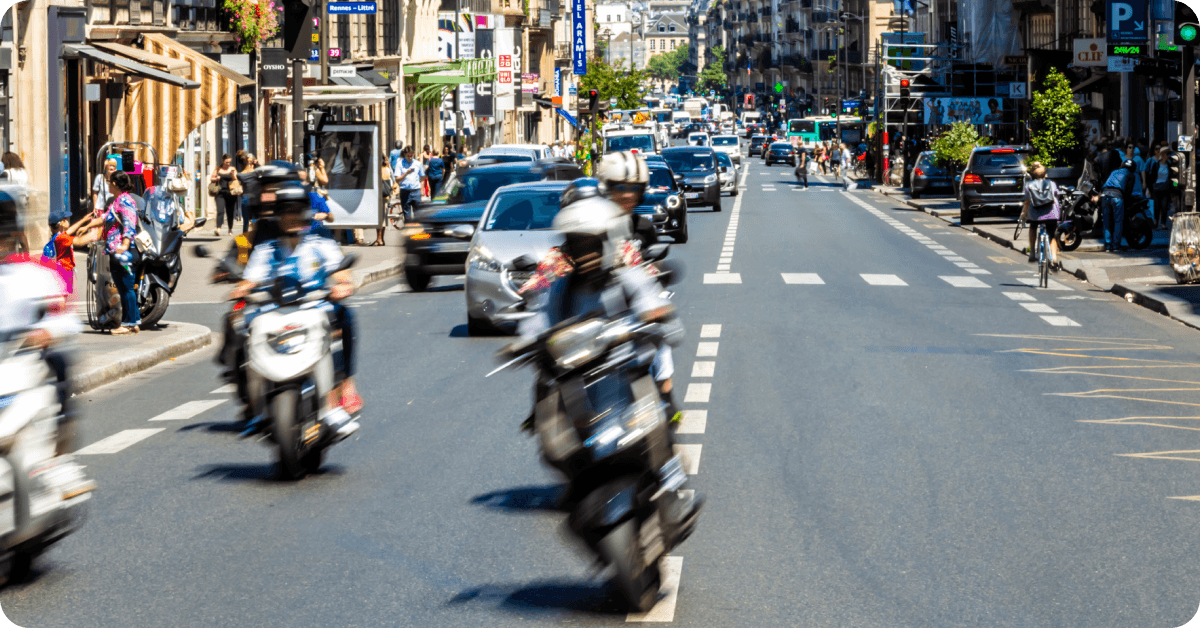 Motorbikes drive along the streets of Paris.
